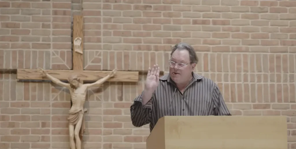 Kevin Matthews explaining Broken Mary movie story in Church with Crucified Jesus in the back
