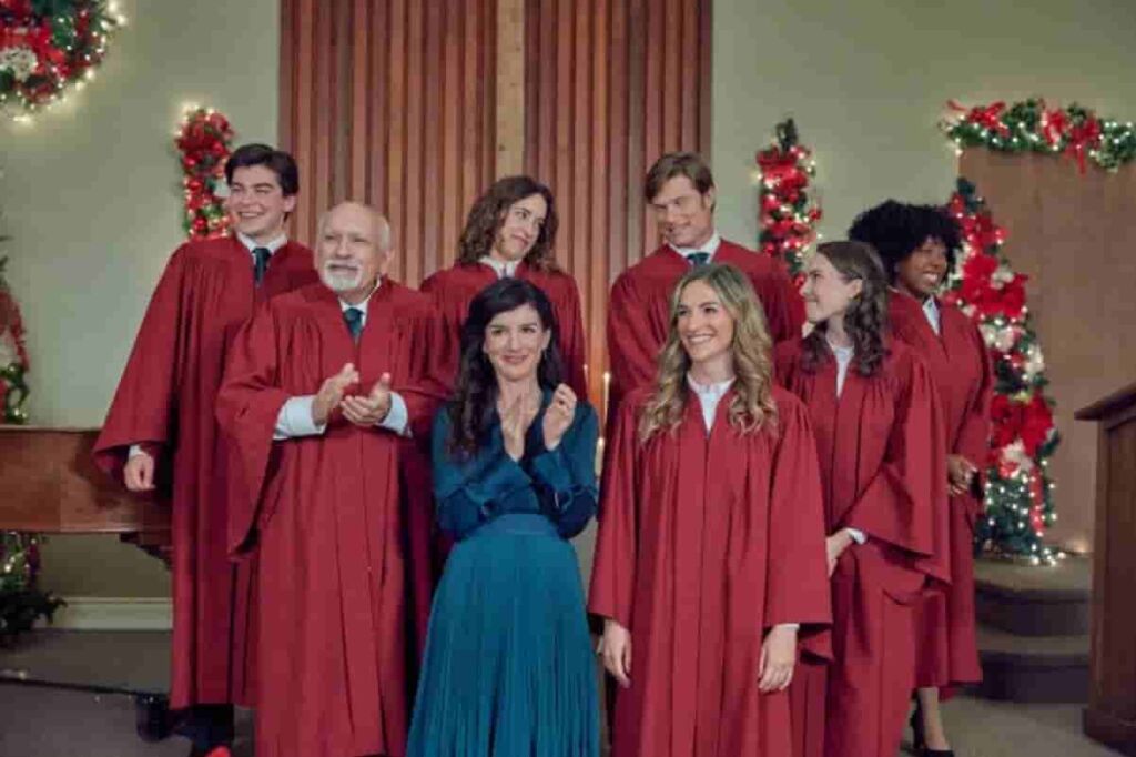 Time for Her to Come Home for Christmas full cast wearing red cassocks, only Shenae Grimes-Beech is wearing purple one 