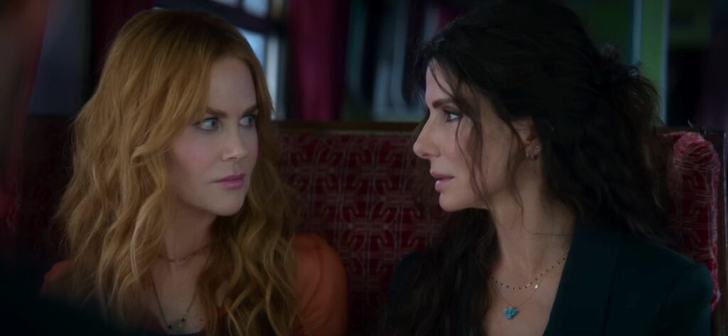 Sandra Bullock and Nicole Goodman staring into each other's eyes in Practical Magic 2 inside a train