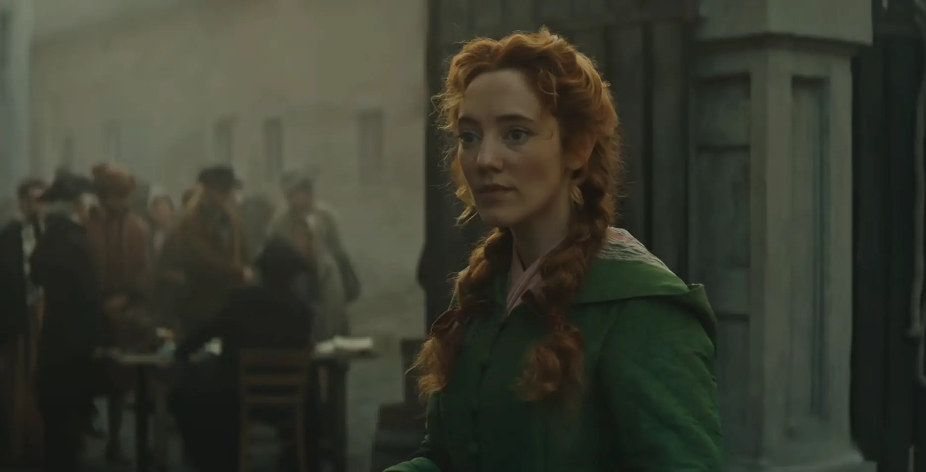 Where was A Tale of Two Cities filmed? Kit Harington's BBC/MGM+ Series A red-haired woman in a green coat (Mirren Mack) stands outside a building in a scene from MGM+’s A Tale of Two Cities, with a group of people blurred in the background